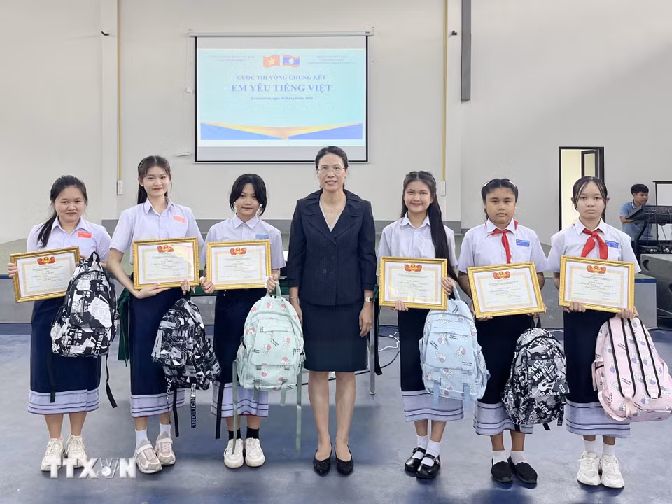 Bà Đặng Thị Hải Tâm, Tổng lãnh sự Việt Nam tại tỉnh Savannakhet trao bằng khen cho các học sinh đoạt giải Cuộc thi vòng Chung kết Em yêu tiếng Việt. (Ảnh TTXVN phát)