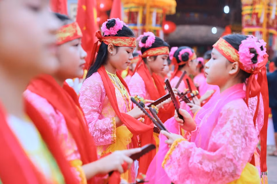 Đội sênh tiền biểu diễn trong phần rước Thánh tại Lễ hội đua thuyền làng Đăm. (Ảnh: Lê Đông/TTXVN)