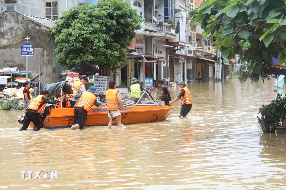 Lực lượng quân đội hỗ trợ nhân dân xã Na Sầm, tỉnh Lạng Sơn di chuyển trong vùng ngập lụt. (Ảnh: Quang Duy /TTXVN)