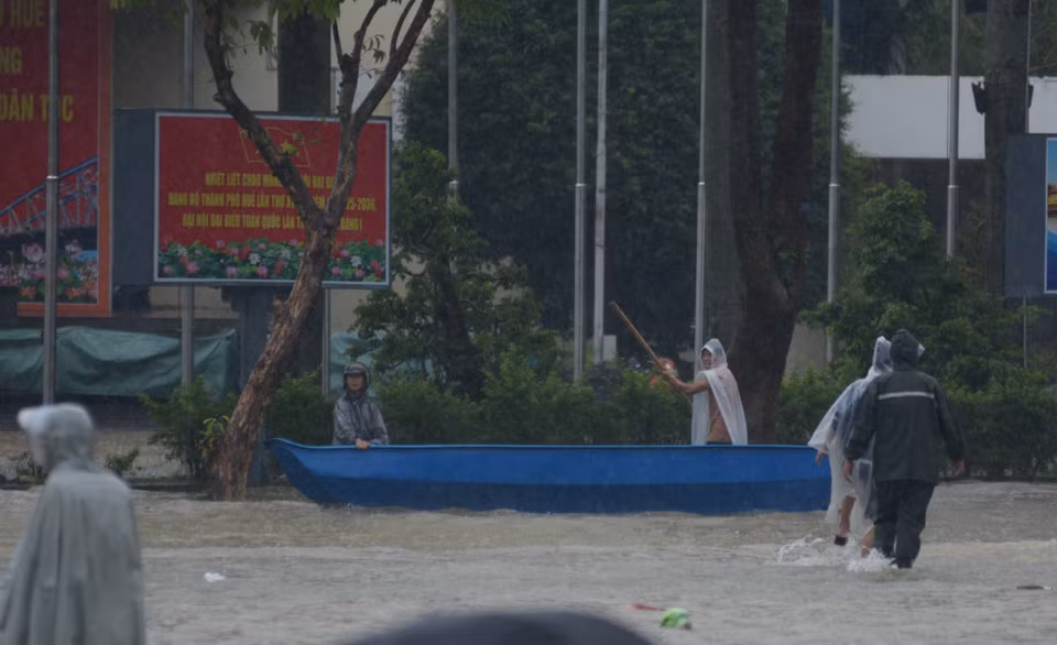 Nhiều người chọn đi bằng thuyền để đi qua các đoạn đường ngập sâu. (Ảnh: Văn Dũng/TTXVN)