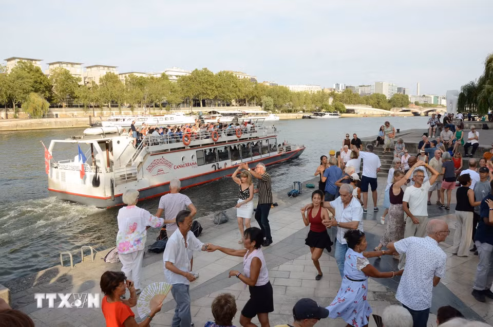 Người dân khiêu vũ bên bờ sông Seine, đoạn chảy qua thủ đô Paris. (Ảnh: Hữu Chiến/TTXVN)