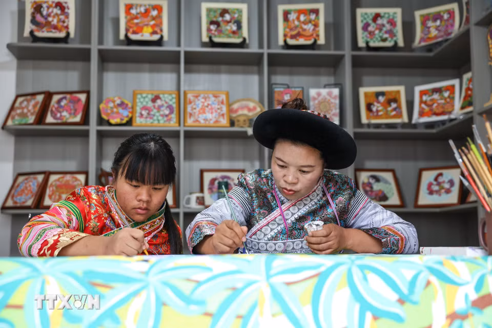 Các "họa sỹ nông dân" vẽ tranh tại huyện Thủy Thành, tỉnh Quý Châu, Trung Quốc. (Ảnh: THX/TTXVN phát)