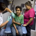 Tiêm phòng mũi vaccine phòng sởi-quai bị-rubella cho học sinh tại Mỹ. (Ảnh: AFP/TTXVN)