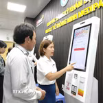 Hướng dẫn người dân đăng ký thủ tục khám bệnh. (Ảnh: Mỹ Hà/TTXVN)