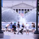 Du khách tránh nắng nóng bên đài phun nước tại khu vực National Mall (Quảng trường Quốc gia) ở thủ đô Washington D.C. (Ảnh: Ngọc Quang/TTXVN)
