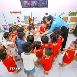 Giáo viên mầm non hướng dẫn trẻ tham gia các hoạt động chăm sóc, giáo dục tại lớp. (Ảnh: Giang Phương/TTXVN)