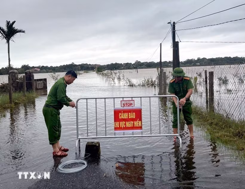 Công an xã Bến Hải (Quảng Trị) lập rào chắn, khuyến cáo người dân tuyệt đối không di chuyển qua các tuyến đường nước ngập sâu. (Ảnh: TTXVN phát)