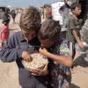 Các em nhỏ được phát bữa ăn cứu trợ tại Khan Younis, Dải Gaza. (Ảnh: THX/TTXVN)