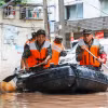Cảnh sát Trung Quốc giúp sơ tán người dân khỏi các khu vực ngập lụt. (Ảnh: AFP/TTXVN)