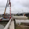 Dự án Kè chống sạt lở bờ sông bảo vệ thị trấn Bến Lức đang được gấp rút thi công. (Ảnh: Minh Hưng/TXVN)