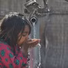 Em nhỏ uống nước từ vòi nước công cộng ở Lahore, Pakistan. (Ảnh: AFP/TTXVN)
