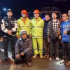 3 du khách được cứu hộ an toàn (đứng gần nhau, thứ 3, 4, 5 từ phải sang) cùng các thành viên đội cứu hộ. (Ảnh: Quốc Hùng/TTXVN phát)