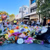 Rất nhiều hoa được người dân Australia đặt bên ngoài Trung tâm thương mại Westfield Bondi Junction để tưởng nhớ các nạn nhân trong vụ tấn công bằng dao chiều 13/4. (Ảnh: Thanh Tú/TTXVN)