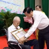 Bí thư Tỉnh ủy Vĩnh Long Bùi Văn Nghiêm trao Huy hiệu 80 năm tuổi Đảng cho đảng viên Đặng Nam Tuấn (Đảng bộ cơ sở phường 4, thành phố Vĩnh Long). (Ảnh: Phạm Minh Tuấn/TTXVN)