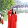 Người dân ghi lại hình ảnh đẹp bên cầu Thê Húc, quận Hoàn Kiếm, trong mùng 2 Tết. (Ảnh: Phạm Kiên/TTXVN)