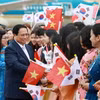 Cộng đồng người Việt Nam tại Hàn Quốc chào đón Thủ tướng Phạm Minh Chính và Phu nhân. (Ảnh: Dương Giang/TTXVN)