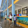 Giáo viên, nhân viên Trường Trung học cơ sở Nam Phương Tiến A dọn vệ sinh trường lớp sau nhiều ngày bị ngập sâu. (Ảnh: Nguyễn Cúc/TTXVN)