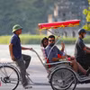 Du khách quốc tế trên xe xích lô đi tham quan phố cổ, Hồ Hoàn Kiếm. (Ảnh: Thanh Tùng/TTXVN)