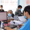 Cán bộ Ủy ban Nhân dân phường Hiệp Bình Chánh, thành phố Thủ Đức, Thành phố Hồ Chí Minh giải quyết hồ sơ cho người dân. (Ảnh: Xuân Tình/TTXVN)