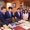 Thường trực Ban Bí thư Lương Cường, Trưởng ban Tuyên giáo Trung ương Nguyễn Trọng Nghĩa với các đại biểu tham quan không gian sách của Nhà xuất bản Chính trị quốc gia Sự thật. (Ảnh: Văn Điệp/TTXVN)