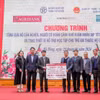 Ông Phạm Đức Ấn - Chủ tịch Hội đồng thành viên Agribank trao tặng quà của Agribank hỗ trợ hộ cận nghèo, đối tượng chính sách quận Hà Đông (Hà Nội) nhân dịp Tết Nguyên đán Giáp Thìn. (Ảnh: Vietnam+)