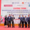 Ông Phạm Đức Ấn - Chủ tịch Hội đồng thành viên Agribank trao tặng quà của Agribank hỗ trợ hộ cận nghèo, đối tượng chính sách quận Hà Đông (Hà Nội) nhân dịp Tết Nguyên đán Giáp Thìn. (Ảnh: PV/Vietnam+)