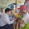Tiến sỹ Lê Quang Trí, Giám đốc Sở Giáo dục và Đào tạo tỉnh Tiền Giang (trái) thăm hỏi cháu bé vừa được giải cứu. (Ảnh: Minh Trí/TTXVN)