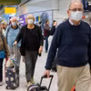 Hành khách đeo khẩu trang phòng dịch COVID-19 tại sân bay Heathrow, London của Anh ngày 19/3. (Ảnh: AFP/TTXVN)