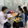 Phụ huynh đưa trẻ đi tiêm vaccine phòng bệnh sởi. (Ảnh: Đinh Hằng/TTXVN)