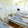 Bác sỹ điều trị cho bệnh nhân mắc sốt xuất huyết tại Bệnh viện đa khoa Đức Giang. (Ảnh: Minh Quyết/TTXVN)