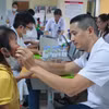 Bác sỹ khám cho trẻ mắc dị tật khe hở môi, vòm miệng. (Ảnh: PV/Vietnam+)