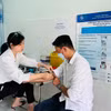 Nhân viên y tế Trung tâm Kiểm soát bệnh tật tỉnh Kiên Giang lấy mẫu xét nghiệm theo dõi điều trị HIV cho một bệnh nhân. (Ảnh: T.G/Vietnam+)