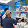 Hướng dẫn người tiêu dùng phân biệt hàng giả tại phòng trưng bày của Tổng cục Quản lý Thị trường. (Ảnh: Đức Duy/Vietnam+) 