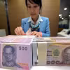Nhân viên ngân hàng kiểm đếm đồng Baht tại Bangkok, Thái Lan. (Ảnh: AFP/TTXVN)
