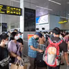 Hành khách xếp hàng làm thủ tục an ninh soi chiếu hàng không trước khi lên máy bay. (Ảnh: PV/Vietnam+)