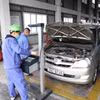 Nhân viên đăng kiểm thực hiện quy trình kiểm định xe. (Ảnh: Minh Hiếu/TTXVN)