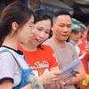 Phụ huynh, thí sinh xem lại bài sau khi rời phòng thi. (Ảnh: TTXVN) 