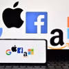 Biểu tượng của Google, Apple, Facebook, Amazon và Microsoft trên màn hình điện thoại và máy tính bảng. (Ảnh: AFP/TTXVN)