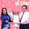 Trưởng Ban Tuyên giáo Trung ương Nguyễn Trọng Nghĩa trao quyết định cho bà Đinh Thị Mai. (Ảnh: Phương Hoa/TTXVN)