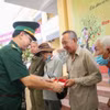 Đại tá Phạm Đình Triệu, Chính ủy Bộ đội Biên phòng Tây Ninh tặng quà cho người dân vùng biên giới. (Ảnh: Giang Phương/TTXVN)