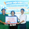 Đại diện các đơn vị, tổ chức tặng quà cho người khuyết tật tại Ngày hội việc làm. (Ảnh: Thanh Vũ/TTXVN)
