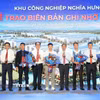 Lãnh đạo tỉnh Bắc Ninh và đại diện chủ đầu tư Khu công nghiệp Nghĩa Hưng tặng hoa chúc mừng các đơn vị tham gia ký kết biên bản ghi nhớ. (Ảnh: Đồng Thúy/TTXVN)