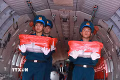 Nghi thức trang trọng chuyển mẫu hài cốt liệt sỹ từ máy bay xuống tại Sân bay Gia Lâm để làm lễ dâng hương tưởng niệm. (Ảnh: Trọng Đức/TTXVN)