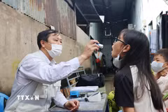 Bác sỹ Trạm Y tế xã Hiệp Phước khám, kiểm tra sức khỏe cho học sinh khu vực ghi nhận ca bệnh não mô cầu. (Ảnh: Đinh Hằng/TTXVN)