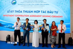 Trao hoa chúc mừng doanh nghiệp ký thỏa thuận hợp tác đầu tư tại Hội nghị xúc tiến đầu tư vào các khu công nghiệp Lâm Đồng năm 2026. (Ảnh: Nguyễn Thanh/TTXVN)