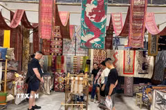Du khách tham quan, mua sắm các sản phẩm dệt thổ cẩm Hoa Tien Brocade. (Ảnh: TTXVN phát)