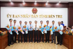 Trao Nghị quyết của Hội đồng Nhân dân tỉnh Bến Tre cho đại diện các cơ quan hợp nhất, sáp nhập. (Ảnh: Huỳnh Phúc Hậu/TTXVN)