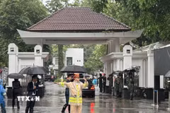 Lực lượng cảnh sát giao thông làm nhiệm vụ điều tiết giao thông trước cửa nhà tang lễ. (Ảnh: Quốc Lũy/TTXVN)