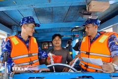 Lực lượng chấp pháp trên biển tại Thành phố Hồ Chí Minh tuyên truyền về chống khai thác IUU cho ngư dân. (Ảnh: Hoàng Nhị/TTXVN)