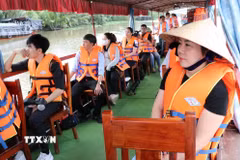 Khách trải nghiệm đi thuyền máy trên sông tại Làng du lịch cộng đồng Nhị Hòa, xã Nhị Long. (Ảnh: Thanh Hòa/TTXVN)